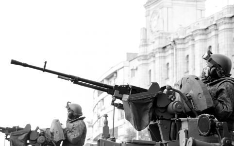 grayscale photo of man holding rifle