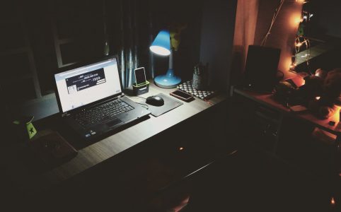 black laptop beside black computer mouse inside room